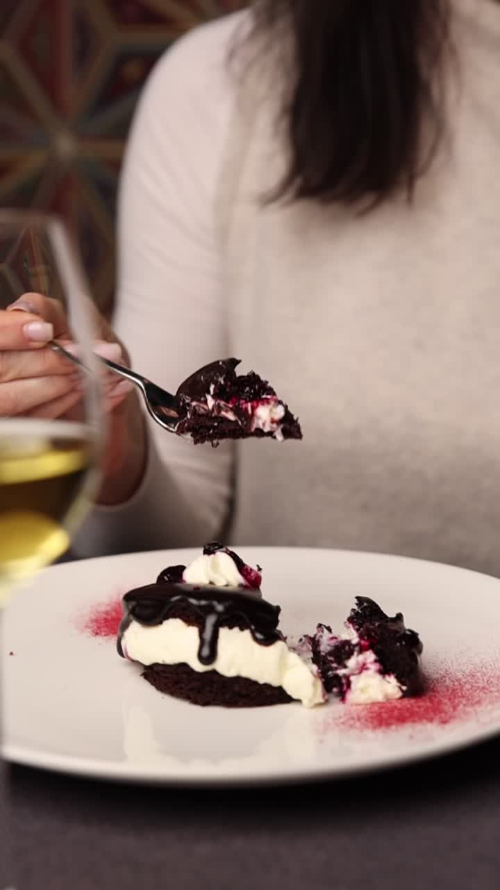Mulher comendo uma deliciosa sobremesa de chocolate com creme e frutas vermelhas