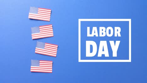 Animation-of-labor-day-text-and-flags-of-usa-on-blue-background