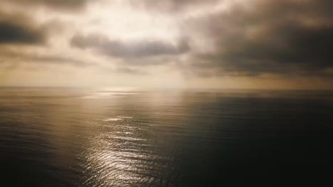 Vista-Aérea-Over-Fog-On-A-Golden-Calm-Ocean-Scene-Suggests-Inspiration-And-Wonder