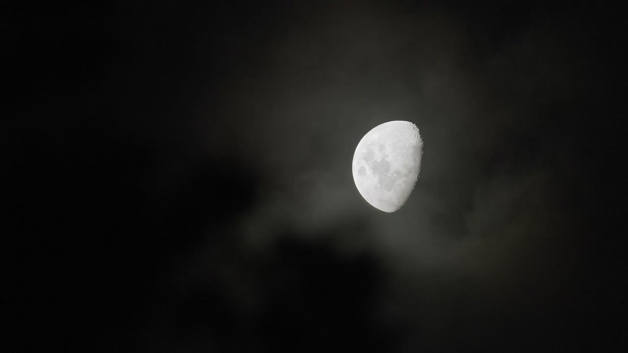 media luna con nubes brumosas rodando por la noche
