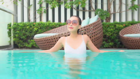 mujer exótica segura en la piscina de un resort caribeño de lujo, cámara lenta