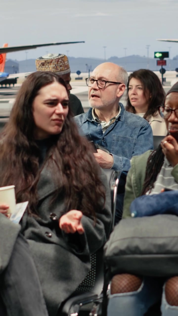 Video verticale. Donne curiose della presenza di truppe dell'esercito nel terminal dell'aeroporto, che scattano foto.