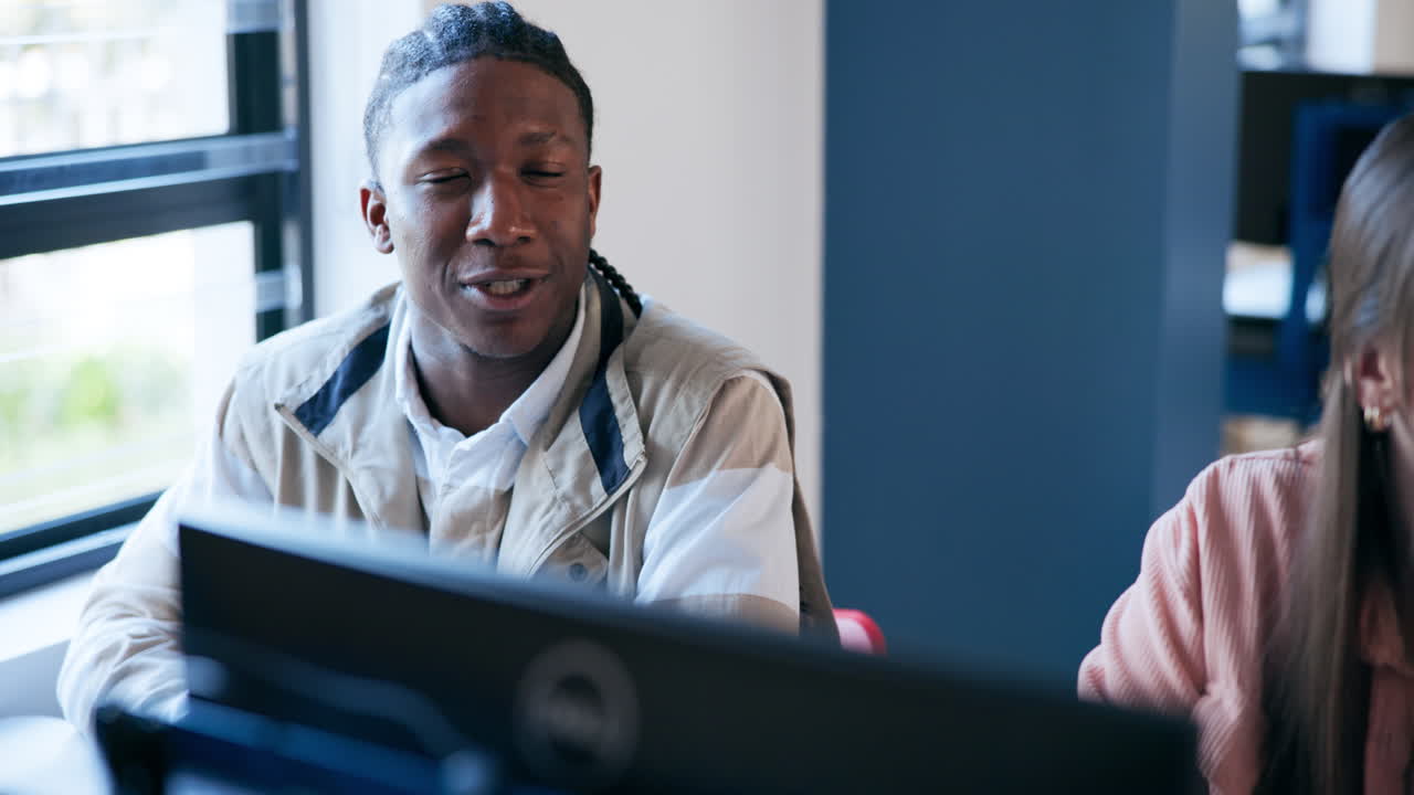 A young man working at a computer in an office
