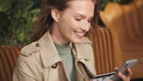 caucasian female student online shopping on smartphone outdoors.