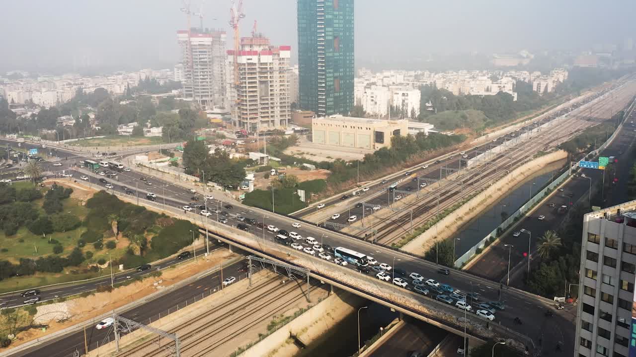 el tráfico en un paso elevado espera a que el semáforo se ponga verde para continuar mientras varios coches pasan por debajo del paso elevado de la autopista a20 en tel aviv en el cruce de la guardia