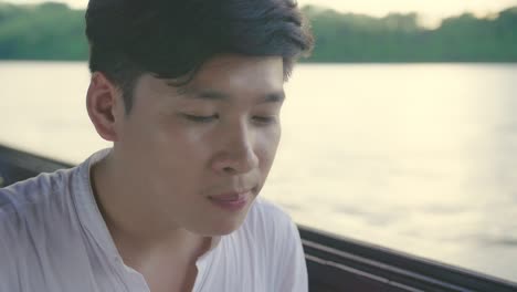 man eating noodles on a boat