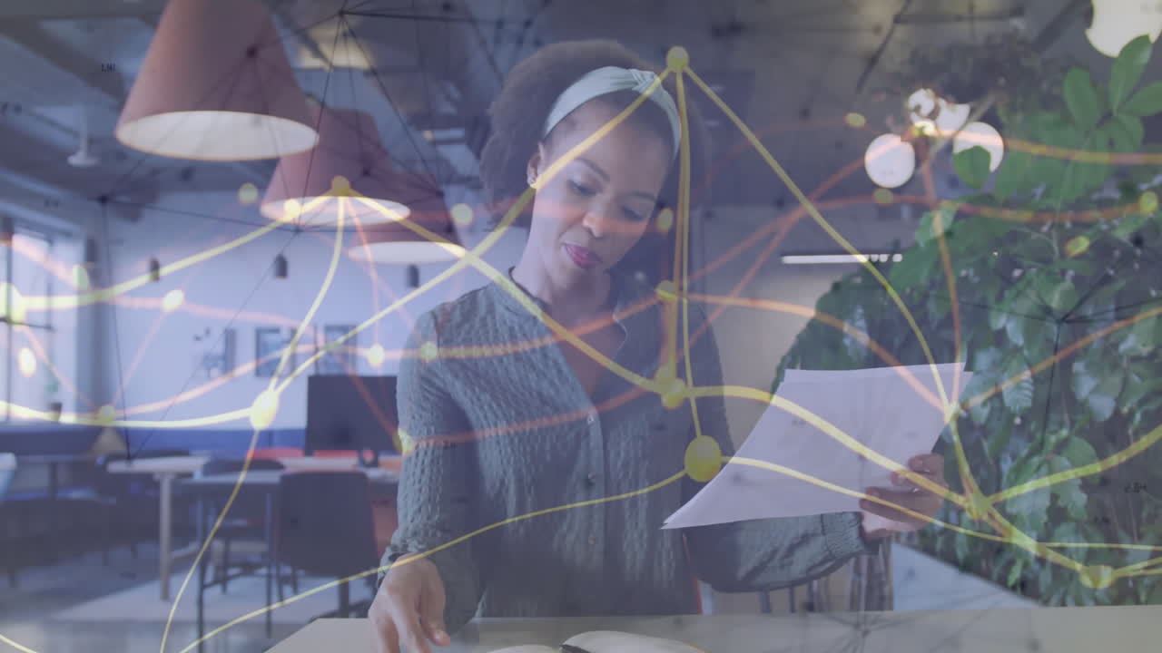 Reviewing documents, businesswoman with network connections animation overlay in office