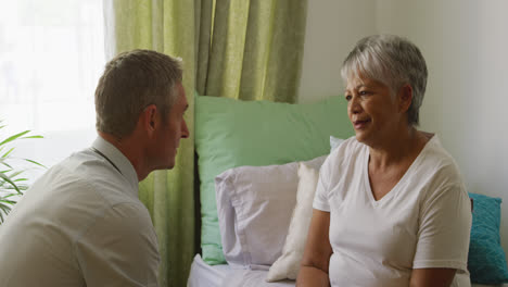 doctor helping senior woman in her room of retirement house