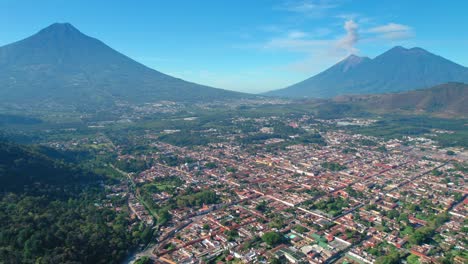 antigua, guatemala con volcanes agua, acatenango y fuego en el fondo con una pequeña erupción de humo