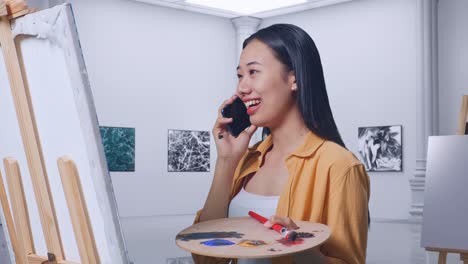 예술 스튜디오에서 전화로 이야기하는 여성 예술가