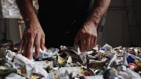 Artist-sifting-through-paints-on-table