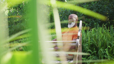 African-american-senior-man-sitting-on-a-bench-in-the-garden