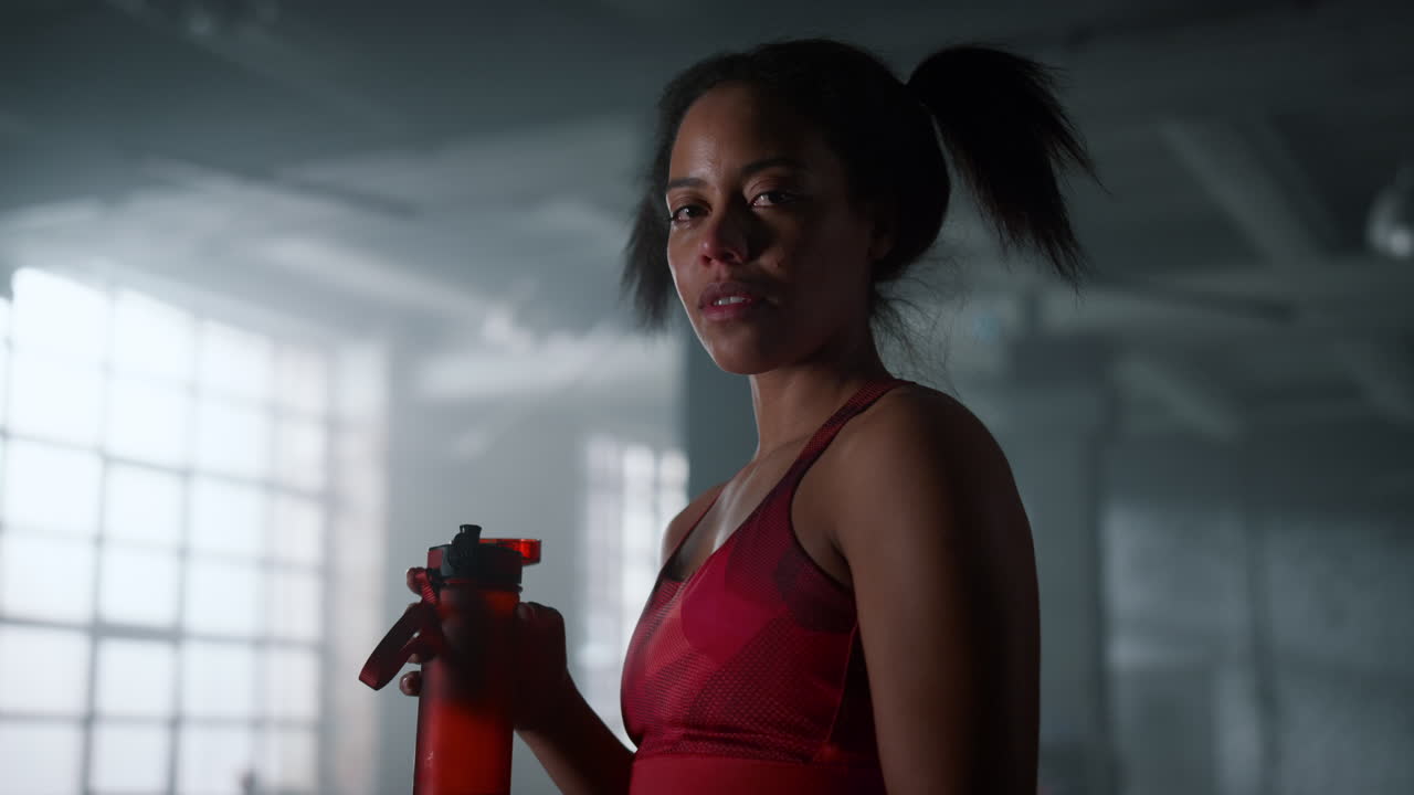 chica mirando a la cámara. culturista sintiéndose cansado después de un entrenamiento de fitness en el gimnasio