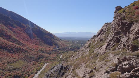 Sweeping-pan-from-mountain-side-to-reveal-valley-and-city-below-in-Salt-Lake-City,-Utah