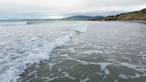 Dramatic-low-flying-drone-by-the-shoreline