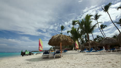 playa tropical con sillas largas y sombrillas