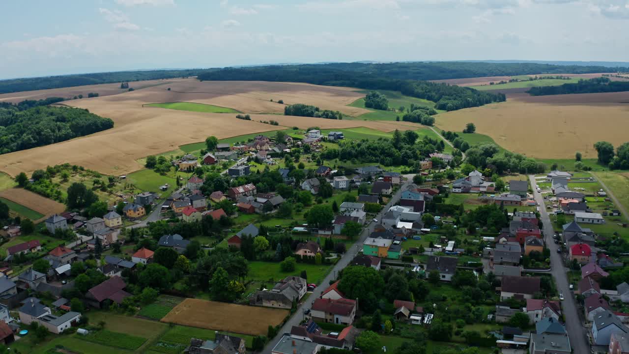 Bredt dronebillede fra luften over en lille tjekkisk landsby og majsmarker i baggrunden.