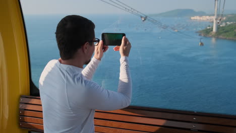 Man taking photo from cable car