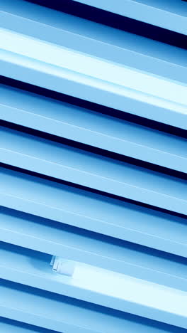 white light of long led lamps among the decorative panels on the ceiling. view from below. vertical video