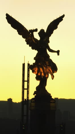 vertical drone shot orbiting the angel of independence statue, dusk in mexico