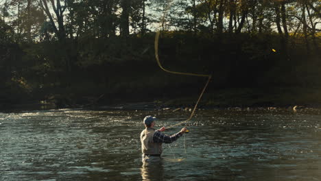 man fly fishing in a river