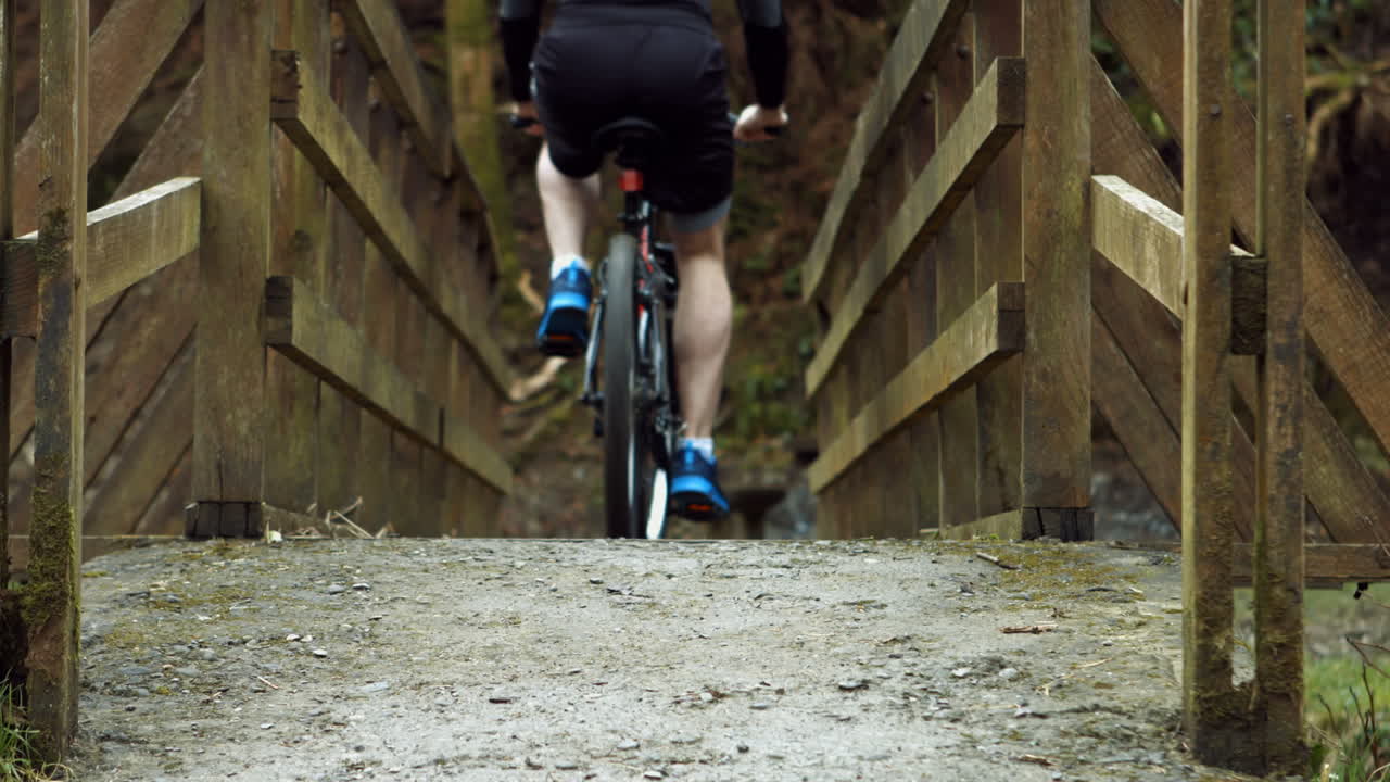 hombre montando su bicicleta sobre el puente