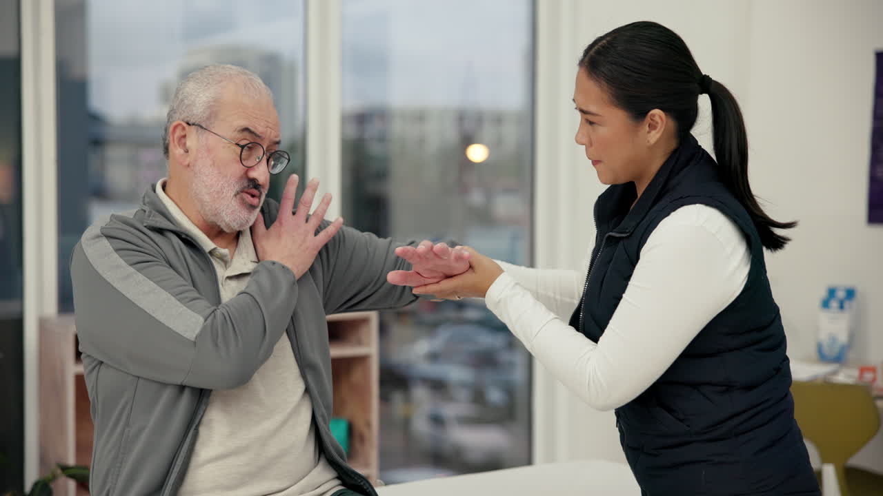 Physical therapist examining senior man in clinic