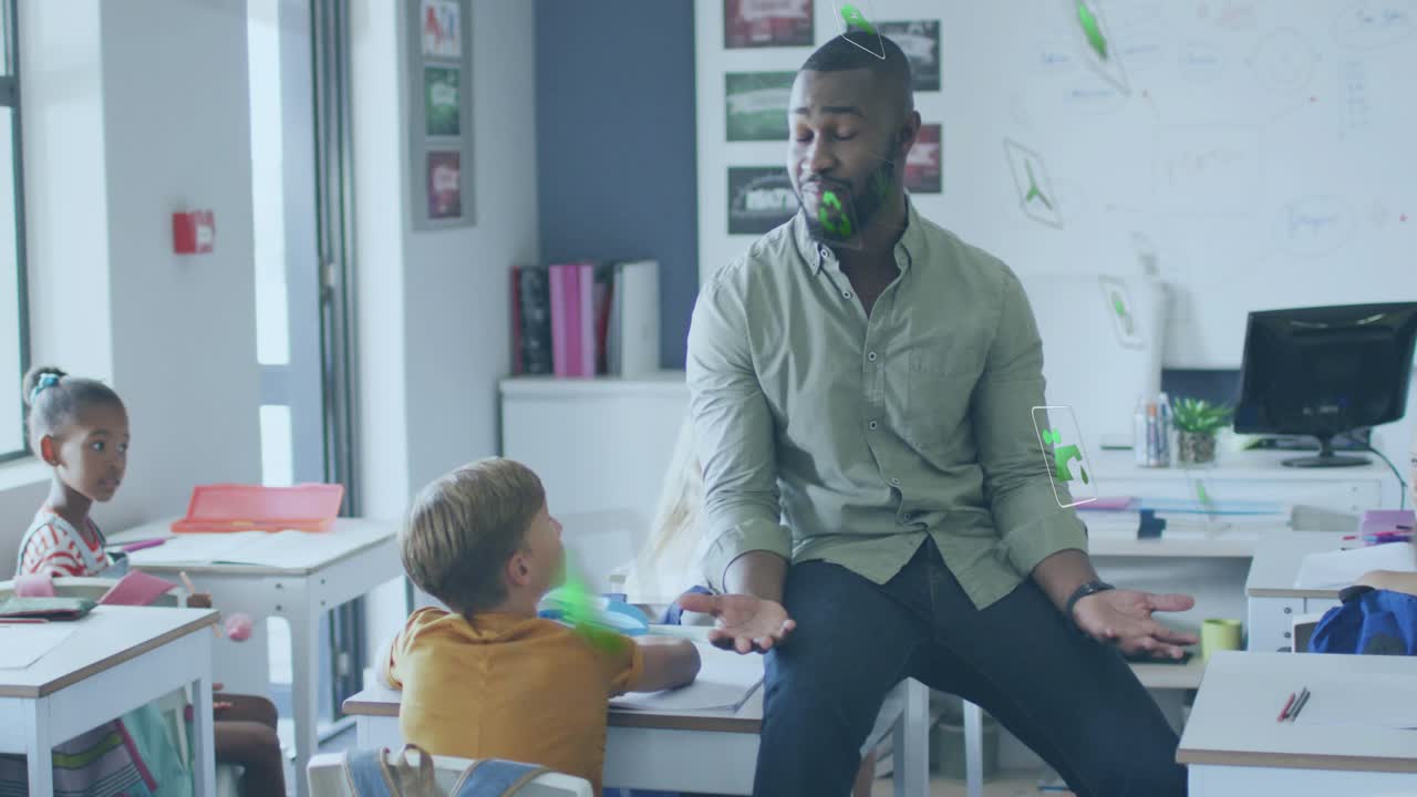 Male teacher entering classroom, perching and gesturing, charts floating while student raising hand