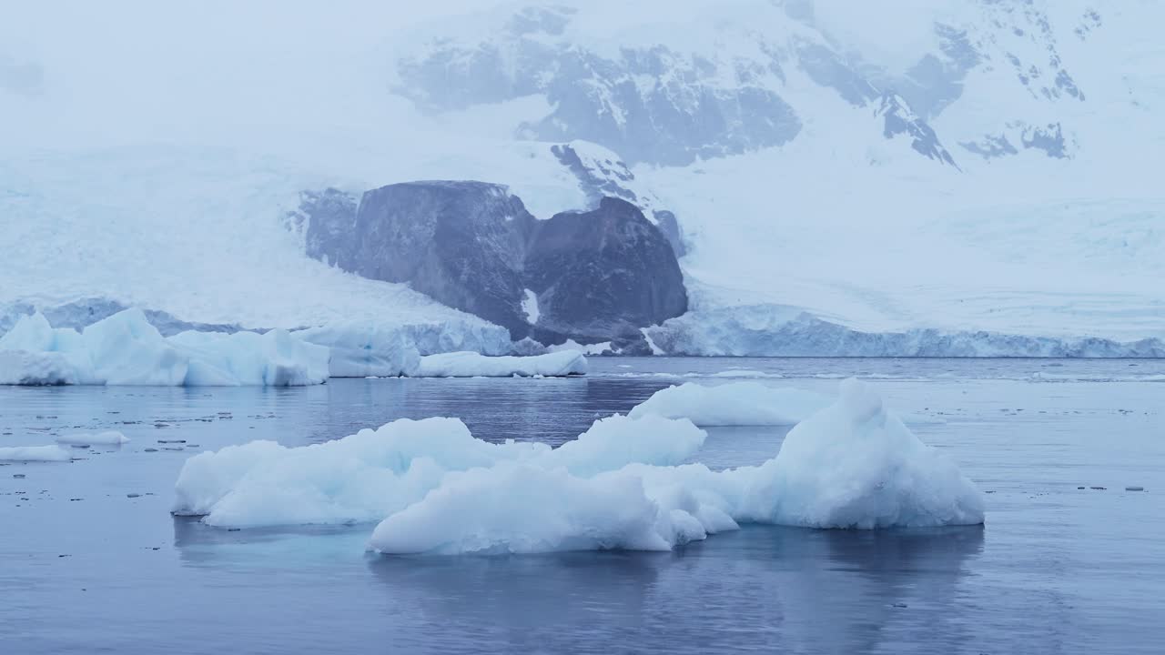 Isbjerg og vinterhav i et koldt, blåt landskab. Antarktisk havlandskab med is og gletsjer i en dramatisk og smuk kystscene på den Antarktiske Halvø, med en stemningsfuld blå atmosfære.