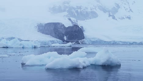 Iceberg-and-Winter-Sea-in-Cold-Blue-Landscape-Scenery,-Antarctica-Seascape-with-Ice-and-Glacier-in-Dramatic-Beautiful-Coastal-Scene-on-Coast-on-Antarctic-Peninsula,-Moody-Blue-Atmosphric