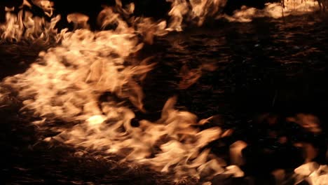 las llamas del fuego se reflejan en el agua negra por la noche