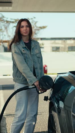 woman filling up car at gas station