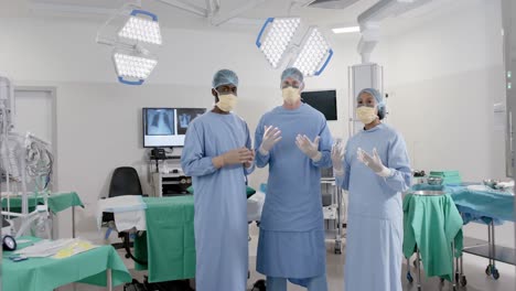 Portrait-of-diverse-surgeons-with-face-masks-in-operating-room-in-slow-motion,-unaltered