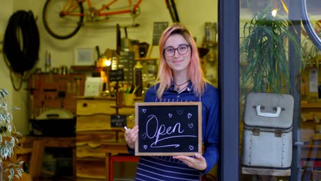Female-owner-holding-chalkboard-with-open-concept-4k
