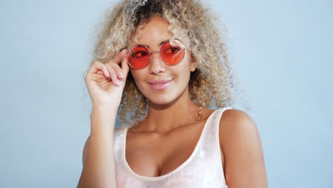 stylish woman with curly hair and orange sunglasses