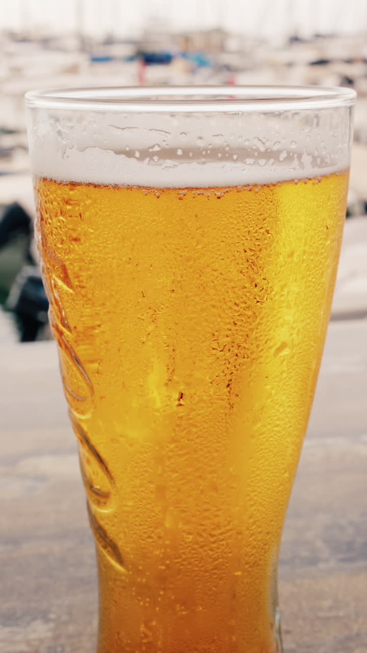 Close up of bubbles forming into foam in a beer glass. Vertical