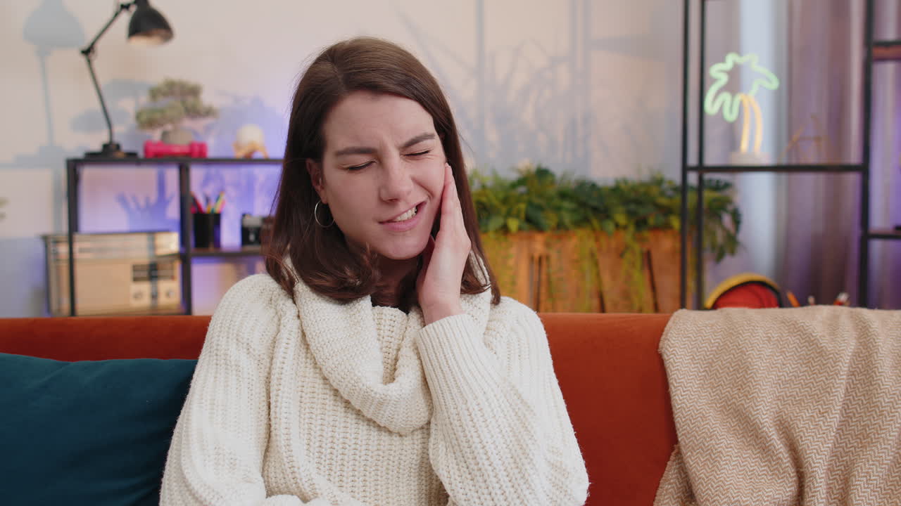 Woman touching cheek closing eyes suffer from painful toothache sensitive teeth cavities at home