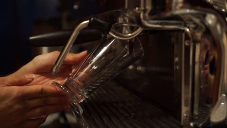 coffee machine prepares espresso in long glass coffee - close up