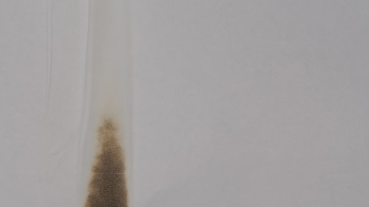 White paper is on fire. The sheet of paper burns, exposing the burnt edges, smokes and turns to ash on green screen chroma key. Abstract burn paper transitions for your projects. Close up. Slow motion