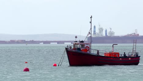 Floating-boat-ancored-to-an-orange-buoy-in-a-sunny-day