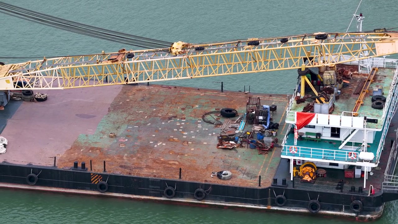 Aerial view of a maritime crane barge anchored on calm ocean waters in Rayong, Thailand.