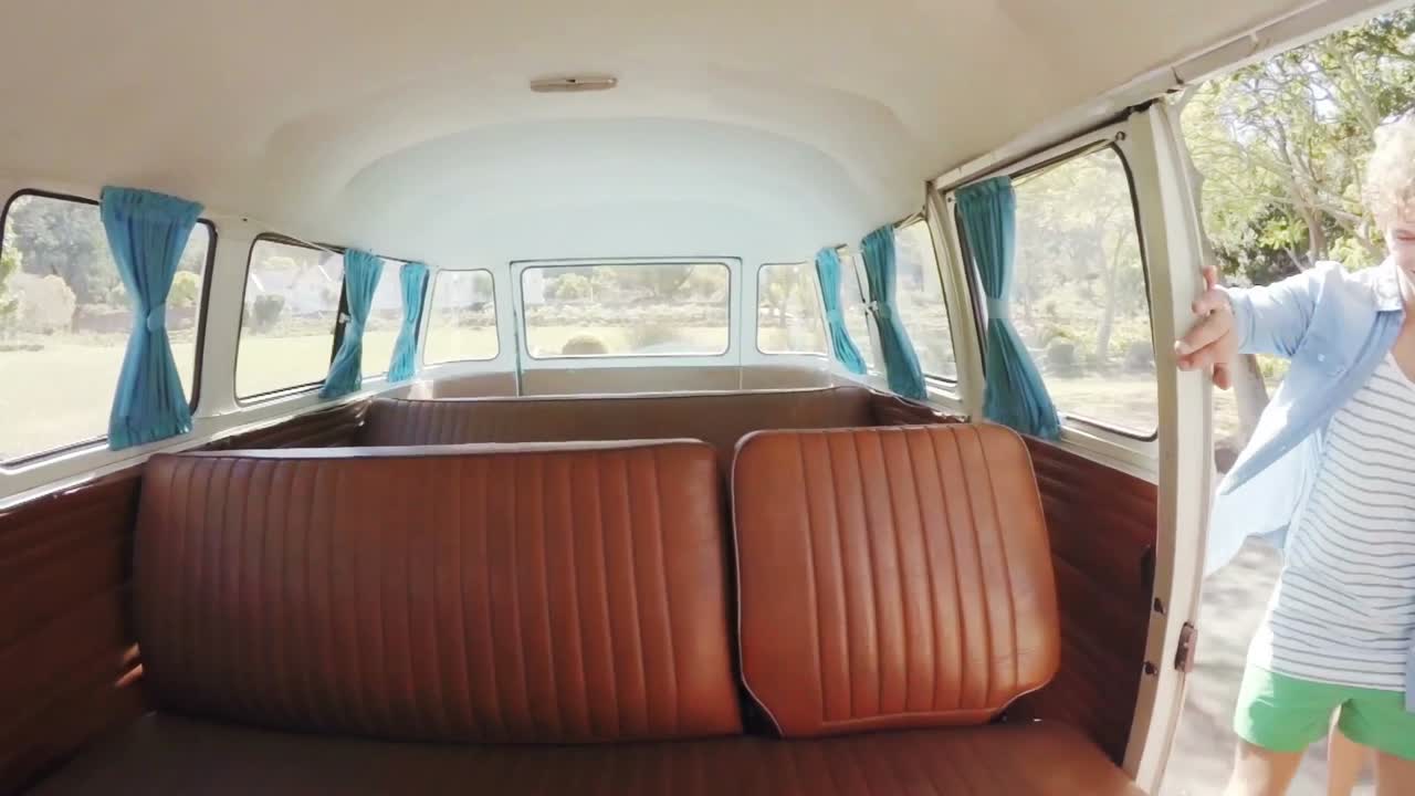 el hipster feliz entrando en la furgoneta