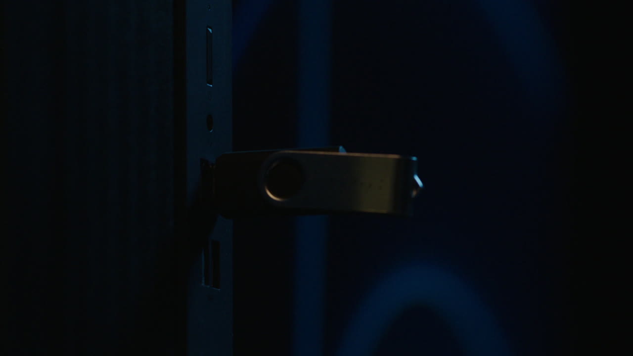 Hand inserting a USB drive into a computer port