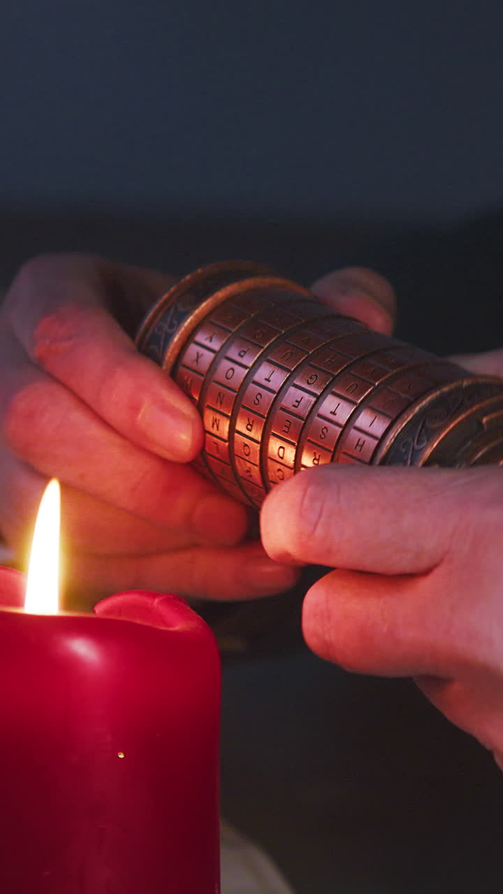 Makro vertikal bernuansa gelap tangan yang mencoba memecahkan cryptex dengan cahaya lilin, membangkitkan nuansa rahasia, ketegangan, dan penceritaan investigatif