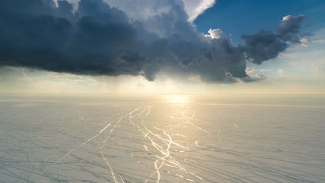 the two people going trough the snow field on the dark cloud background