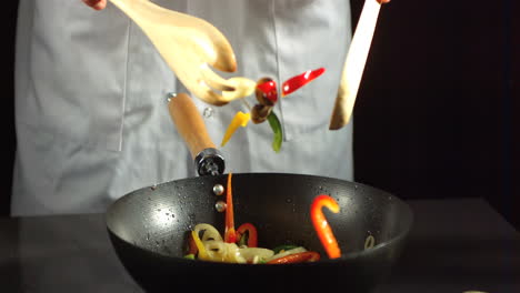 chef mixing vegetable stir fry in a wok