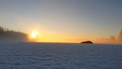 Bewegender-Nebliger-Nebel-Auf-Dem-Zugefrorenen-See-Bei-Goldenem-Sonnenuntergang-An-Einem-Eiskalten-Wintertag-In-Lappland