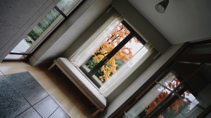 Rotating camera revealing centered window seat in foyer to show orange tree through sheer curtains