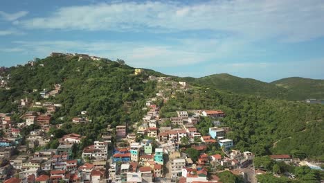 Drone flies backwards revealing the stunning town of Arraial do Cabo in Brazil