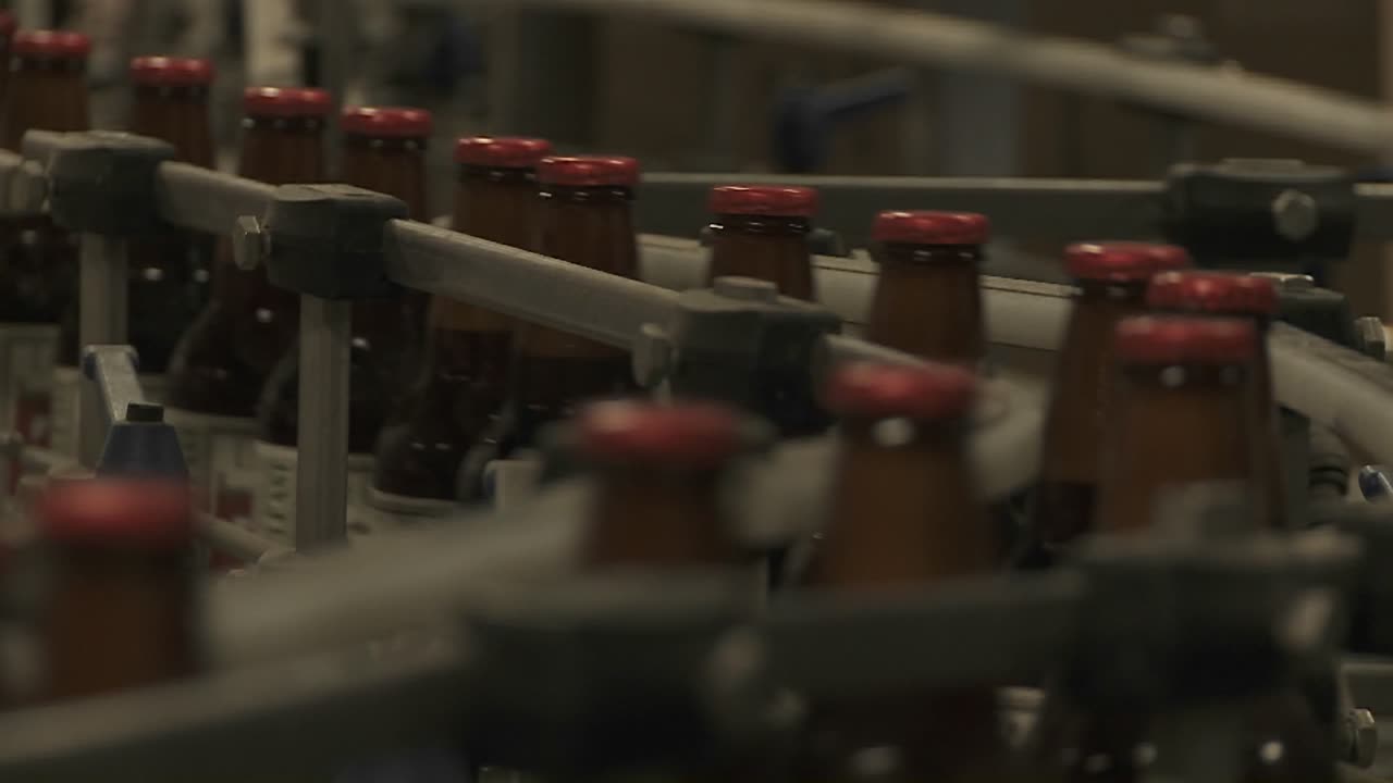 flasker zip langs et transportbånd i et flaskeanlegg